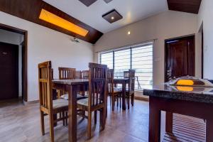 a dining room with a table and chairs at Super OYO Collection O 81054 G Silver Srj Thaneesh Residency in Ooty
