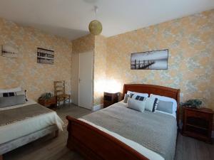1 dormitorio con 2 camas y papel pintado de color amarillo en Maison Saint-Brevin-les-Pins, 5 pièces, 8 personnes - FR-1-364-66, en Saint-Brevin-les-Pins