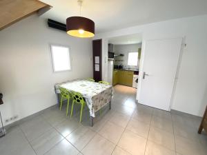 une salle à manger avec une table et une cuisine dans l'établissement Maison La Tranche-sur-Mer, 3 pièces, 4 personnes - FR-1-22-298, à La Tranche-sur-Mer