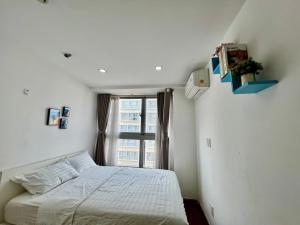 a bedroom with a white bed and a window at SECC Scenic Valley Apartment in Ho Chi Minh City