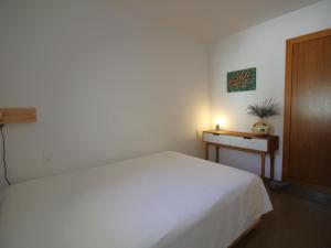 - une chambre avec un lit blanc et une table dans l'établissement Apartamento Llançà, 2 dormitorios, 6 personas - ES-228-82, à Llançà
