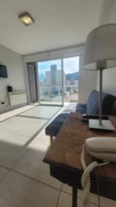 sala de estar con sofá y mesa con lámpara en Dean funes suites 302 en Salta
