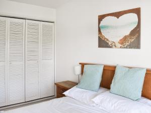 1 dormitorio con paredes blancas y 1 cama con almohadas azules en Saltbox 5 en Yarmouth