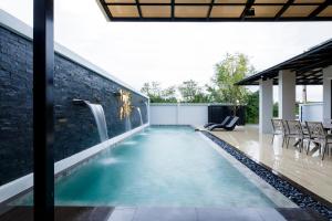 Nue Hatyai Pool Villa في هات ياي: مسبح لا نهاية له في منزل مع شلال