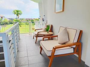 a balcony with two chairs and a table with a view at Casa Due in Canggu