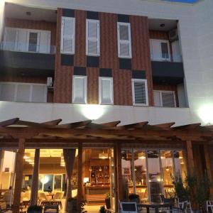 a building with a restaurant with tables in front of it at Real Resort Albania in Fushë-Draç +11 photos