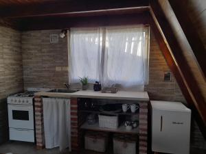 a kitchen with a stove and a sink and a window at Casa Alpina in Navarro