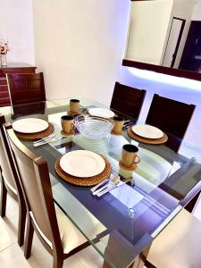 a glass dining table with plates and cups on it at APARTAMENTO FERROCARRIL 201 in Ibagué