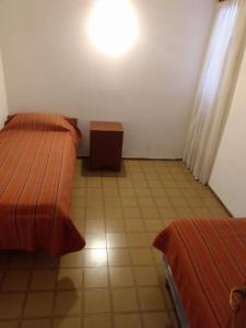 a room with two beds and a table in it at Etels House - Departamentos Mina Clavero in Mina Clavero