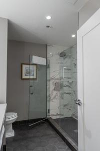 uma casa de banho com uma cabina de duche em vidro e um WC. em Foundry Hotel Asheville, Curio Collection By Hilton em Asheville