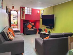 ein Wohnzimmer mit Sofas und einem Flachbildfernseher in der Unterkunft Jaichi Saitama in Cajamarca