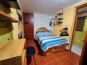 ein Schlafzimmer mit einem Bett und einem Schreibtisch darin in der Unterkunft Jaichi Saitama in Cajamarca