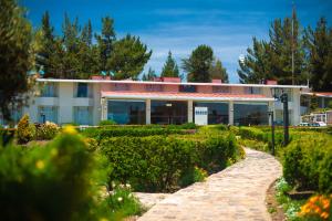 um edifício com um jardim em frente em Lake Titicaca Hotel em Puno