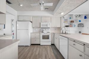 a kitchen with white cabinets and a white refrigerator at Venice Lakefront Pool Home in Venice