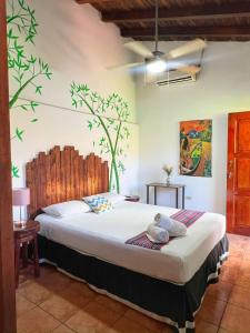 sypialnia z łóżkiem z malowidłem drzewnym na ścianie w obiekcie Hotel Al Sole w mieście León