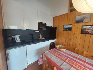 a kitchen with a table and a sink and a counter top at Appartement cosy avec terrasse à Courchevel 1350 - FR-1-514-44 in Courchevel