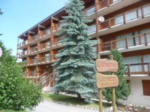 a christmas tree in front of a building with street signs at Appartement cosy avec terrasse à Courchevel 1350 - FR-1-514-44 in Courchevel