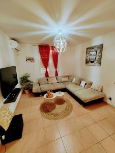 a large living room with a couch and a tv at les Aliceas appartement cosy in Baie-Mahault