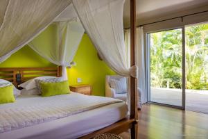 a bedroom with a bed and a large window at Luxury Vacation Villa 6 in Pointe Milou