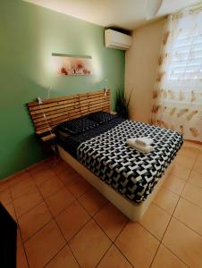 um quarto com uma cama numa parede verde em les Aliceas appartement cosy em Baie-Mahault