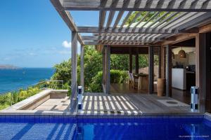 a house with a swimming pool with a view of the ocean at Luxury Vacation Villa 6 in Pointe Milou