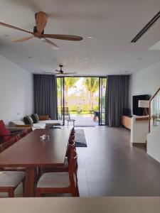 Thuận BiênにあるVilla sanctuary Resort - Bai bien rieng ho tramのリビングルーム(木製テーブル、天井ファン付)