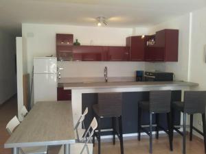 uma cozinha com armários vermelhos e um balcão com cadeiras em Apartamento Sant Pere Pescador, 1 dormitorio, 4 personas - ES-89-129 em Sant Pere Pescador