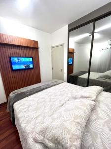 1 dormitorio con 1 cama y TV de pantalla plana en Flat Premium -Acesso a pé ao shopping Center vale - Edifício Summit (Ar condicionado), en São José dos Campos
