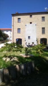 un gran edificio con un patio de césped delante de él en Le Viole B&B en Mergo