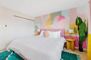1 dormitorio con cama blanca y pared colorida en Bachelorette! Fire Pit+Heated Pool+3MI to Old Town, en Scottsdale