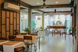 un ristorante con tavoli, sedie e pianoforte di Buri Gallery House a Chiang Mai