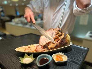 a man is preparing a turkey on a table at EN RESORT Re'Cove Hakone in Hakone +26 photos