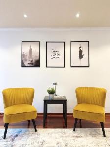 dwa krzesła i stół w pokoju z obrazami na ścianie w obiekcie Elegant Spacious 4BR House in Upscale Neighborhood w mieście Richmond Hill