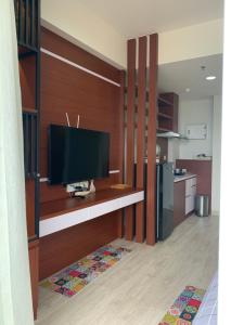 a living room with a television on a shelf at Golf Resort View at Kaina Tower Nuvasa Bay 9B22 in Nongsa