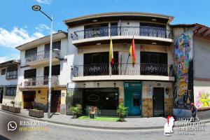 een gebouw met twee vlaggen ervoor bij Ronda Hotel Boutique by Chat Noir in Cuenca