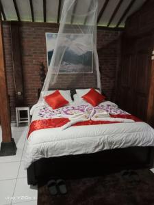 a bedroom with a bed with red pillows at Villa Mak Cik in Yogyakarta