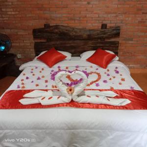 a bed with two hearts and towels on it at Villa Mak Cik in Yogyakarta