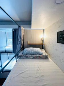 uma cama num pequeno quarto com uma cama gmaxwell gmaxwell gmaxwell gmaxwell gmaxwell em LATALAND HOSTEL em Cidade de Ho Chi Minh