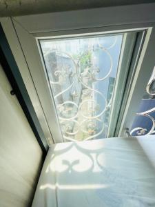 a window with a bed in a room with a view at LATALAND HOSTEL in Ho Chi Minh City