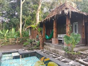 una pequeña casa con una piscina frente a ella en Villa Mak Cik, en Yogyakarta