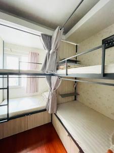 a room with bunk beds with a window at LATALAND HOSTEL in Ho Chi Minh City
