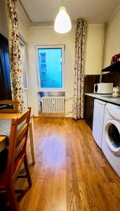 eine Küche mit einer Waschmaschine und einem Fenster in der Unterkunft Fast Wi-Fi + Kitchen + In the Heart of Sofia in Sofia