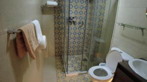een badkamer met een douche, een toilet en een wastafel bij Ronda Hotel Boutique by Chat Noir in Cuenca