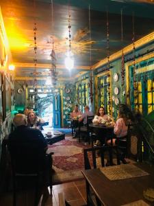 un grupo de personas sentadas en mesas en un restaurante en Serendipity Lake Artistic Bungalow by Heidis Home en Nuwara Eliya