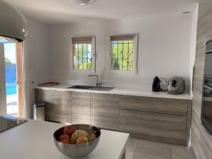 une cuisine avec un bol de fruits sur un comptoir dans l'établissement Villa avec piscine à débordement et climatisation, Côte d'Azur - FR-1-768-71, aux Issambres