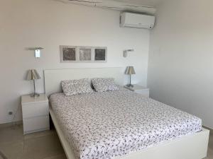 - une chambre blanche avec un lit et deux lampes dans l'établissement Villa avec piscine à débordement et climatisation, Côte d'Azur - FR-1-768-71, aux Issambres