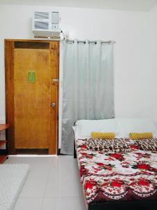 a room with a bed and a door with a window at LR Hostel and Cafe in Moalboal