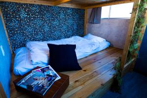 een kleine kamer met een bed in een bakstenen muur bij R Hostel Namba south in Osaka