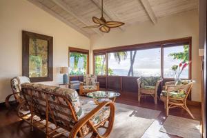 a living room with chairs and a ceiling fan at Maluhia ~ Peace & Tranquility in Haleiwa