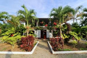 ein Haus mit Palmen davor in der Unterkunft PARADISE LODGE in Tena